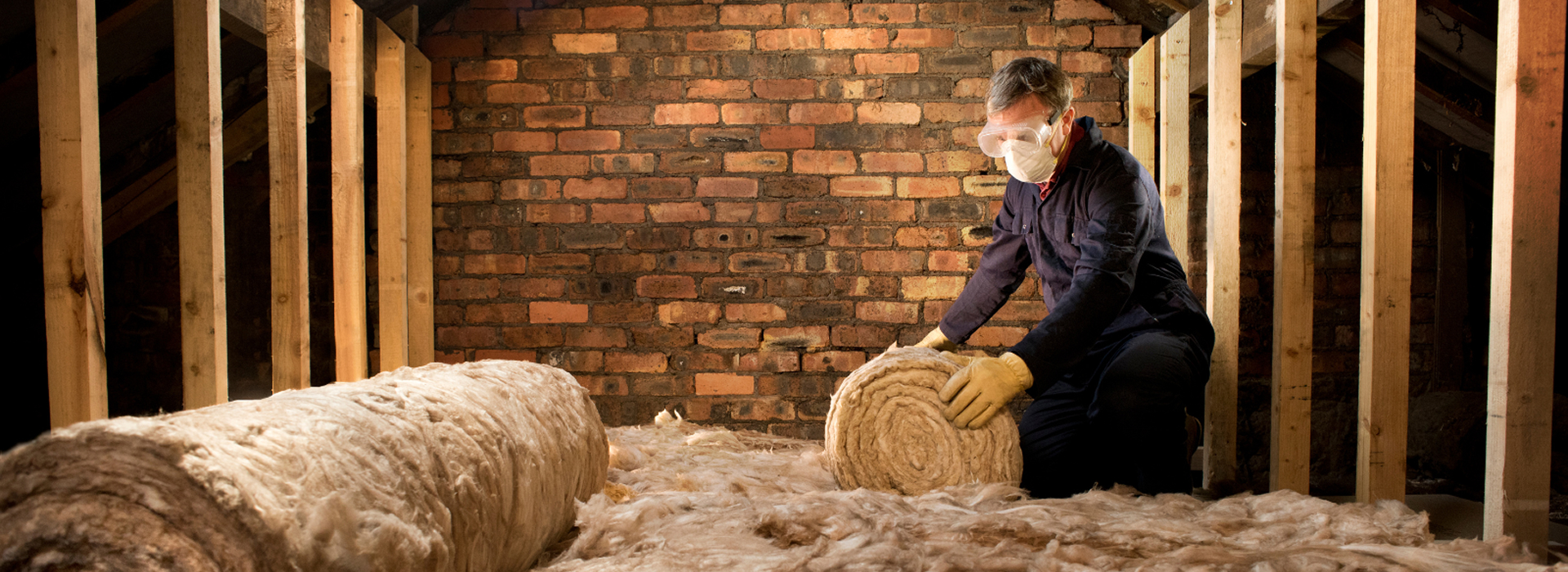 Man placing insulation in a house