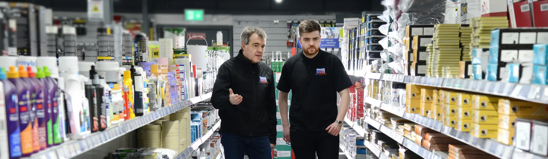 Two employees walking through a paint store