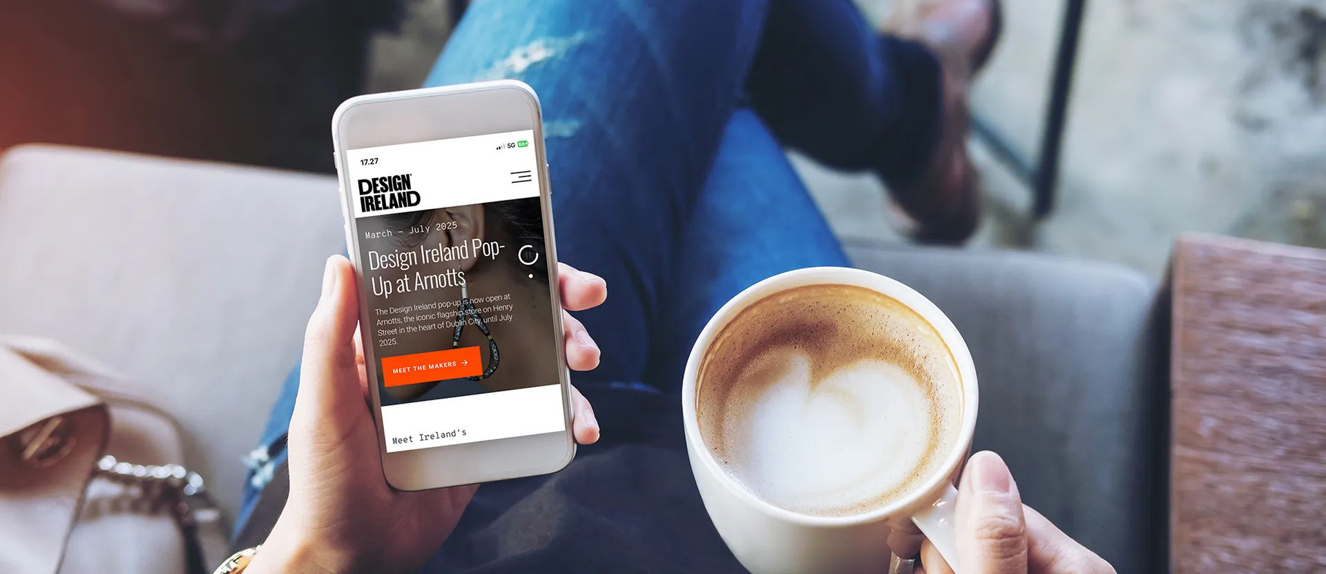 Image of a mobile user of the design Ireland website with a coffee