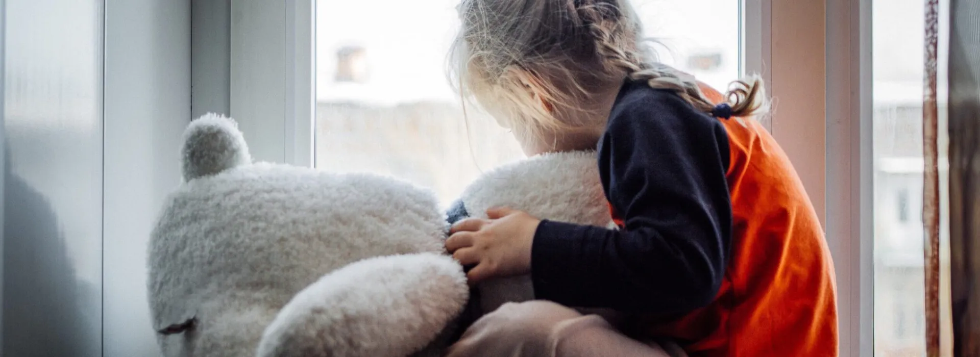 Child hugging her teddy bear